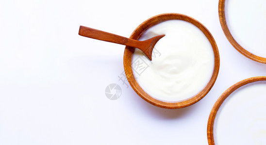 酸奶在白色背景的木碗里图片