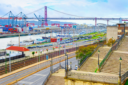 通往Tagus河Libon商业港口的铺面楼梯船舶起重机集装箱背景的第25座阿普里尔桥图片