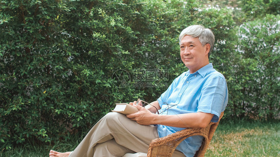 亚裔高龄男子在家休息亚裔高龄男享受休息时间穿着眼镜阅读书籍图片