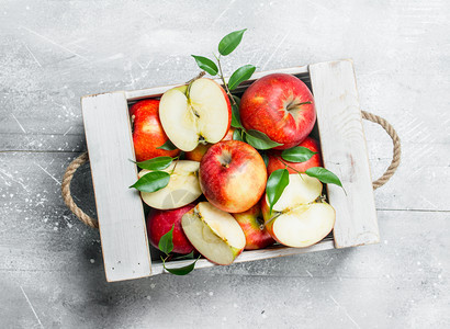 红多汁苹果和切片放在木箱中生锈背景图片