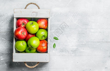 木箱里有多汁的新鲜绿苹果和红白色的生锈背景图片