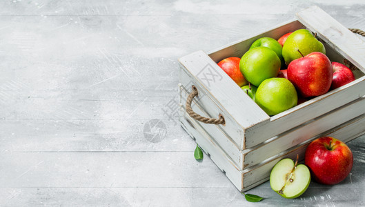木箱里有多汁的新鲜绿苹果和红白色的生锈背景图片