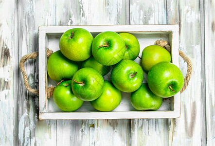 绿色多汁的全苹果放在木箱里白色头背景图片