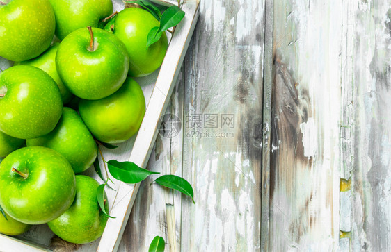 绿色多汁的全苹果放在木箱里白色头背景图片