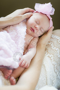 母亲温柔的手抱着她珍贵新生女婴图片