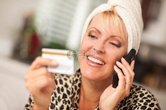 带着微笑的被抢女人在手机上看着她的信用卡图片