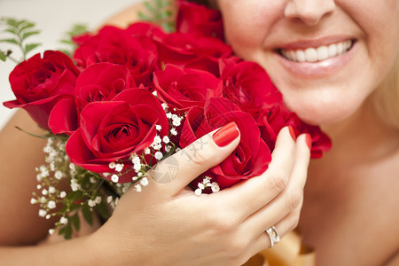 美丽的微笑女人带着一束红玫瑰图片