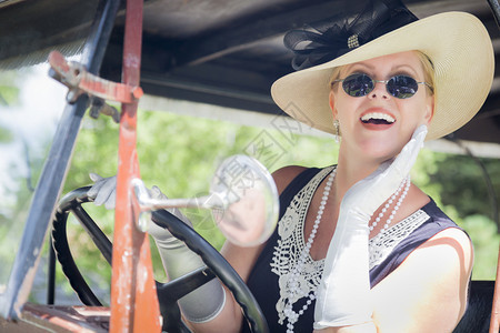 身穿二十年代服装的美女驾驶古董汽车图片