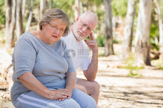 心烦意乱的老妇人和关心的丈夫在户外坐一起图片