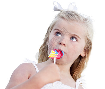 可爱的小女孩享受她的棒糖孤立在白色背景图片
