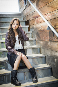 穿着皮靴和夹克坐在楼梯上的年轻成女子穿着皮靴和夹克图片