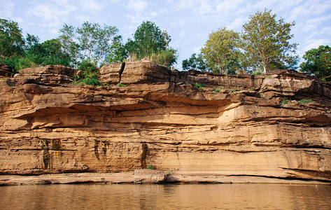黄沙岩峡谷悬崖海岸线有清晰的Mekong河土壤层和悬崖顶端的绿林禁止使用chanuboratchniTlnd图片