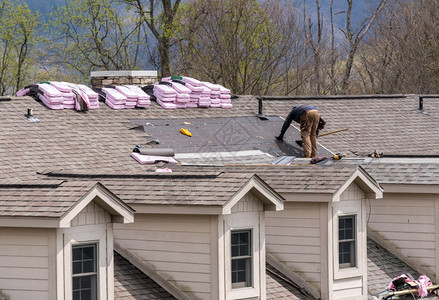 房顶承包商拆除旧瓷砖然后在市政楼屋顶上用新的闪光板替换房顶承包商将旧的闪光板从准备更换屋顶的上搬走图片