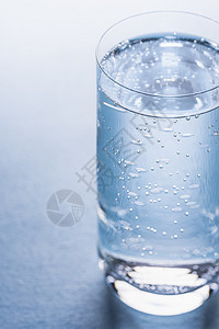 杯子里的冷调水反映了背景上的蓝色与气泡密合的调水图片