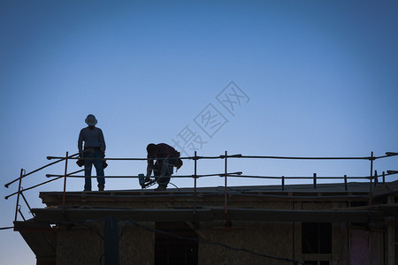 建筑工人站在楼顶上的背影图片