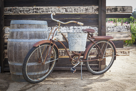 古老的董自行车和酒桶在生锈的户外环境图片