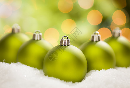 美丽的毛特绿色圣诞装饰品在雪片上抽象的背景上图片