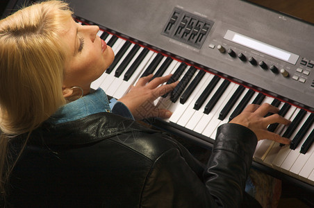 女音乐家在弹数码钢琴时唱歌图片