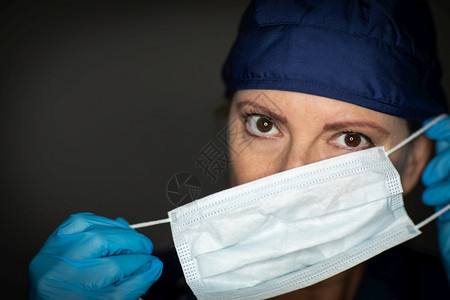 女医生或护士佩戴外科手套上医疗面罩图片