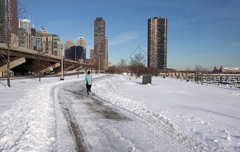 在芝加哥市中心的现代建筑跑步者忍受着寒冷图片