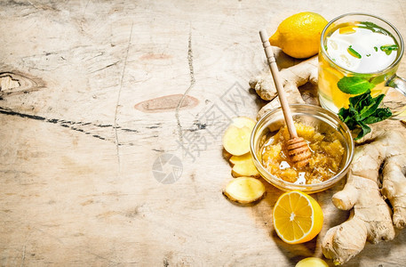 含薄荷和柠檬的姜茶木制背景图片