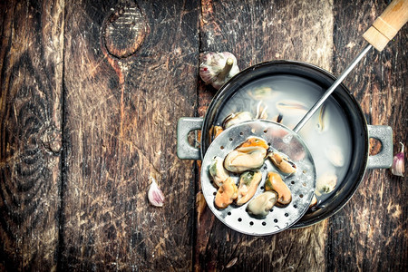 碗里煮熟的贝壳木质背景图片