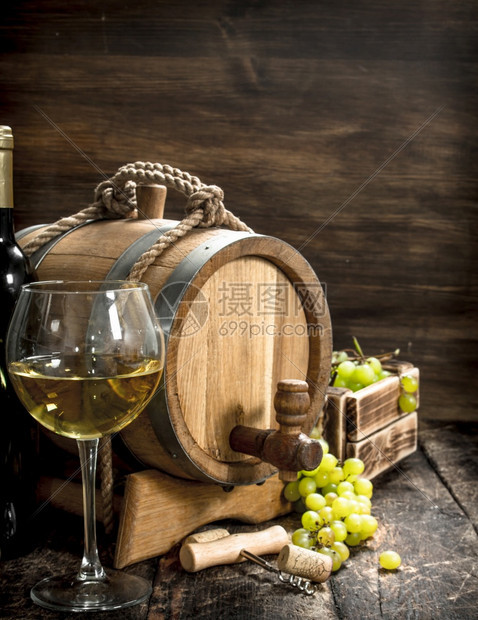 白葡萄酒背景一桶白葡萄酒配有绿枝子木制背景红酒配有绿葡萄枝子图片