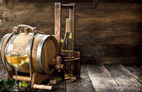 白葡萄酒背景一桶白葡萄酒配有绿枝子木制背景红酒配有绿葡萄枝子图片