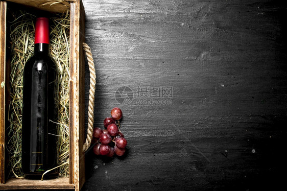 红酒瓶装在旧盒子里葡萄枝在黑板上红酒瓶装在葡萄枝的旧盒子里图片