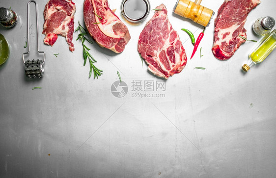 一堆新鲜生牛肉含迷迭香和辣椒生锈背景的新鲜生牛肉图片