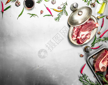 一堆新鲜生牛肉含迷迭香和辣椒生锈背景的新鲜生牛肉图片