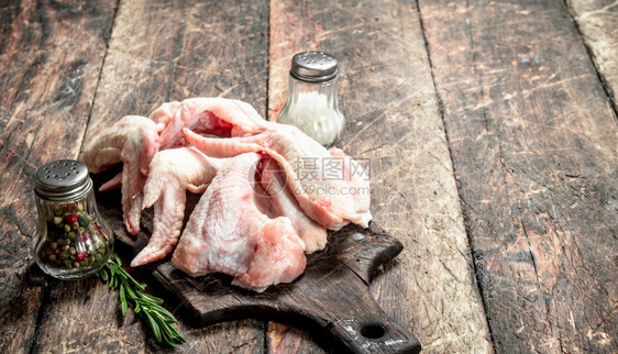 生鸡翅配有香料和草药放在木制桌上生鸡翅配有香料和草药图片