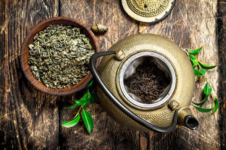 茶壶加绿色印度木制背景图片