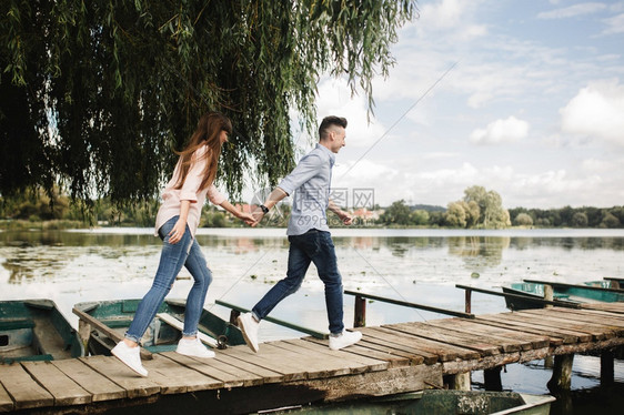 情侣在湖边木桥上牵手图片