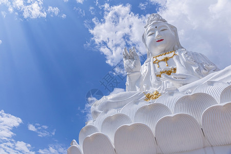 蓝色的天空和云长雕像在华丽广场的康古寺庙清莱的泰王国图片