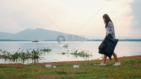 在海滩上收集塑料垃圾韩国女志愿者帮助保持自然清洁收集垃圾环境保护污染问题的概念图片