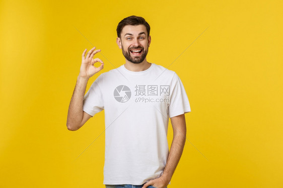 一位在黄色背景上被孤立的快乐年轻男子画像图片