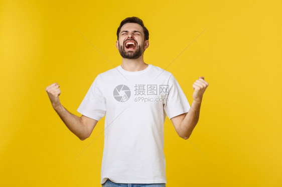快乐的年轻人带着孤立的双臂在黄色背景上图片