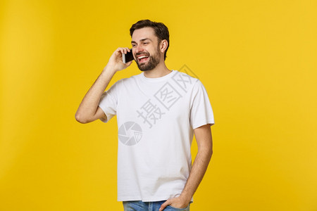 青年临时工在黄背景的电话上说图片
