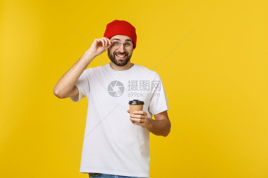 以孤立的黄色气将咖啡放在外卖纸杯中并微笑着因为他会从白天开始图片