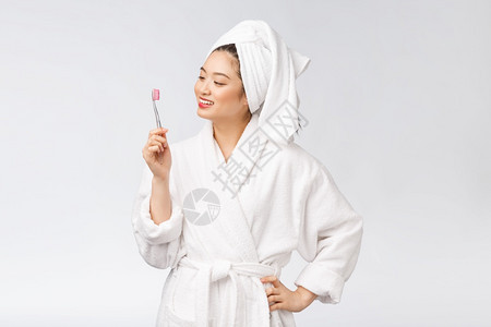 有牙刷和的亚洲人快乐女在浴袍的早晨心情中图片
