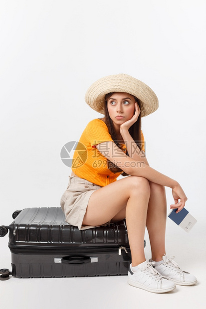 生活和旅行概念年轻美丽的高加索女坐在一个小箱子上等待她的飞行孤立于白色背景之上生活方式和旅行概念年轻美丽的高加索女坐在一个小箱子图片