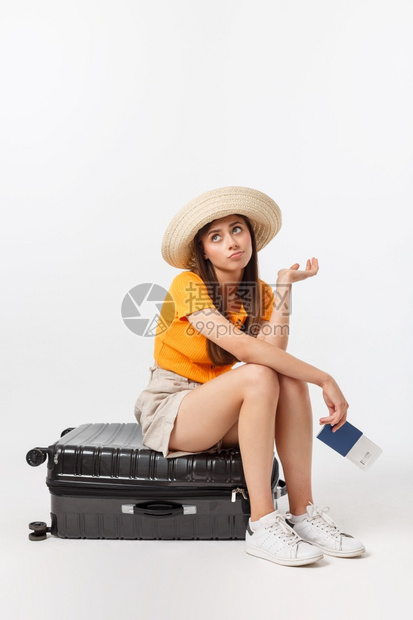 生活和旅行概念年轻美丽的高加索女坐在一个小箱子上等待她的飞行孤立于白色背景之上生活方式和旅行概念年轻美丽的高加索女坐在一个小箱子图片