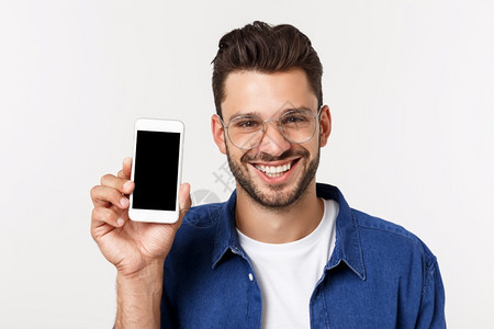 年轻人展示他的新智能手机孤立在白色上图片