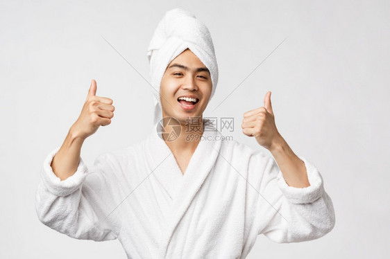 欢乐快笑和的asin男子在浴袍展露大拇指上示推荐和批准伟大的度假胜地真棒酒店看起来乐观白色背景复制空间美丽spa和休闲概念欢乐真图片