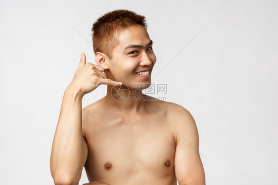美丽人与家庭概念英俊可爱的裸亚洲男人近身肖像看起来很高兴笑着调情问他打个电话在耳边白色背景显示电话标志美丽笑着调情显示电话标志图片