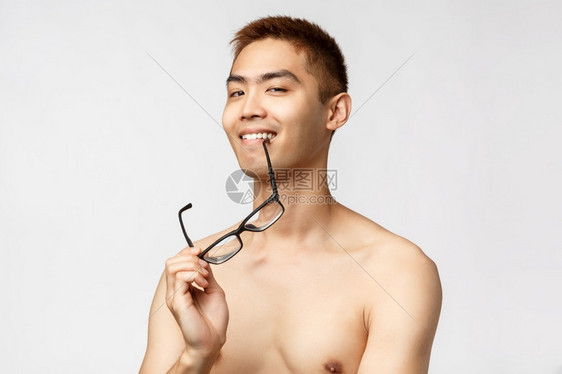 美丽人与生活方式概念自信和高尚的亚裔男人近身肖像赤咬着眼镜的边缘笑高兴看着摄影机知道一些有趣的东西自信和高尚的亚裔男人近身肖像眼图片