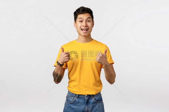 兴奋快乐笑的年轻男穿着黄色t恤展示支持手势鼓励某个人做伟大的如计划白色背景听起来有趣好主意兴奋笑的年轻男穿着黄色t恤展示拇指在批图片