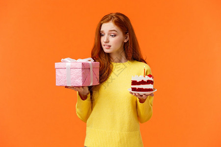 庆典礼物和假日概念可爱的红发女孩看着诱惑渴望礼物盒拿着包装的礼物一件美味的b日蛋糕生女孩想要解包的惊喜庆祝礼物和假日概念可爱的红图片