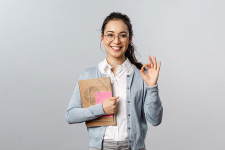 带着眼镜的女孩手上抱着笔记本图片